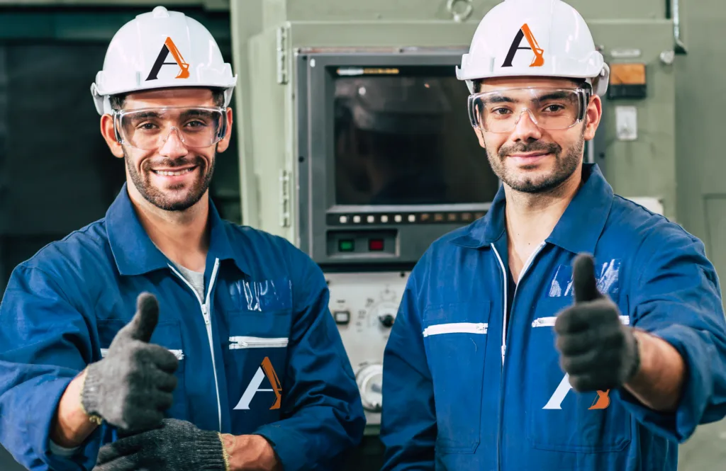 A pair of construction workers with branded uniforms; coveralls and hard hats, giving thumbs up